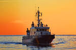 Zollboot PRIWALL im Licht der aufgehenden Sonne in der Ostsee vor Travemünde. August 2022