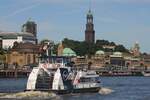 Hadag Hafenfähre HAMBURGENSIE; Eigner/Betreiber: Hadag; Aufnahmeort: Elbe/Hafen Hamburg, Deutschland; Datum: 30.06.2025; Info:(ENI 04810920) Fährschiff Typ 2000 / HADAG / Lüa 29,92 m, B 8,26 m, Tg 1,7 m / 2 Diesel, Volvo Penta D 13-C, ges. 662 kW (900 PS), 2 Ruder-Propeller, SRP 200, 12 kn / max. 250 Pass., Sitzplätze Hauptdeck 124, Oberdeck 88 / 2013 bei SSB, Oortkaten, Hamburg / dieses Schiff wurde als 13. dieses Typs in Dienst gestellt. Das Bild zeigt die Hamburgensie vor den St.Pauli Landungsbrücken, der Kuppelbau links im Bild ist der nördliche Zugang zum Alten Elbtunnel.