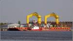 Der Ponton T.O.W. III liegt beladen mit zwei Tripods am 23.04.2011 im Kaiserhafen von Bremerhaven. Er ist 86 m lang, 27 m breit und hat einen Tiefgang zwischen 1 und 5 m. Der 27 m lange Schlepper TAUCHER O. WULF 4 (IMO 7800564) hat an ihm festgemacht.