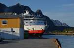 Die Finnmarken  schiebt sich nach ablegen langsam  an einer Halle am Hafen Svolvaer hervor.