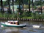 Diese kleine Yacht zieht im Amsterdam-Rijnkanaal eine Art Badewanne hinter sich her;100903