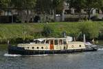 Motorboot Leonie in gemütlicher Fahrt zu Tal auf der Maas in Maastricht.
