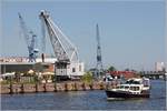 Die Motoryacht BALEIA fährt in den Lübecker Hansahafen ein. Im Hintergrund drei ältere Hafenkrane. 23.07.2019