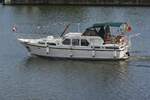 Dieses Motorboot fährt gemächlich auf der Maas bei Maastricht spazieren.