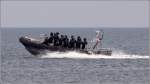 Ein RIB (Festrumpfschlauchboot) mit Blaulicht, der Landesdienstflagge von Mecklenburg-Vorpommern im Heck und elf vermummten Gestalten an Bord prescht am 16.06.2011 von Rostock-Warnemnde aus in die Ostsee. Vermutlich ist es die Polizei, die hier unterwegs ist.