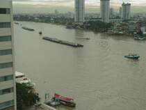 Mit Einsetzen der Flut in der Bucht von Bangkok, die das Wasser des Chao Phraya Flusses zur�ck dr�ckt, kommen die Schleppverb�nde um die Lastk�hne flu�aufw�rts zu ziehen. Hier sind 3 Schleppverb�nde zu sehen, au�erdem ein Expressboot sowie ein Hotel-Shuttleboot