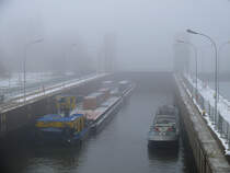 Bei ziemlich dichtem Nebel liegen das Frachtschiff BERTA und ein Schubverband von Hamburg kommend in der Geesthachter Schleuse; 07.12.2010
