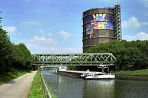 Rhein-Herne-Kanal. Motorschiff  Spree  hat Oberhausens Wahrzeichen, den Gasometer, passiert (4. Juni 2007). Der Gasometer dient auch als Litfa�s�ule. Gerade wird Werbung f�r den Movie Park in Bottrop angebracht.