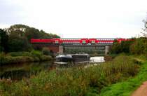 �ber den ELK f�hrt der IR Fehmarn von Hamburg kommend, sowie im ELK das Binnenschiff Norderstedt in Richtung L�beck. Ein nicht allt�glicher Blick in H�he Genin zum ELK... Aufgenommen: 23.9.2011