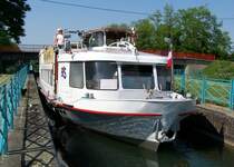 Das Tagesausflugschiff  Kaiserstuhl  (ex  Annemarie  aus K�nigswinter) der Breisacher Fahrgast-Schiffahrt GmbH, liegt am 13.06.2006 in der Schleuse Nr.63 (Ecluse No.63) des Rhein-Rh�ne-Kanals. Diese liegt auf halber Strecke zwischen den Ortschaften Artzenheim und Kunheim. Hier f�hrt das Schiff Richtung Breisach. Euronummer: 4304700 / Heimatort: Breisach / Baujahr 1960 / Schiffswerft Schmidt in Oberkassel (Deutschland) / L�nge �ber alles: 22,75 m / Breite �ber alles: 4,90 m / Tiefgang: 0,88 m / Verdr�ngung: 36,0 m� / 122 Fahrg�ste / Deutz F8L 418 (8-Zyl.V-Motor / Diesel), 164 PS (120 kW) bei 2150 U/min