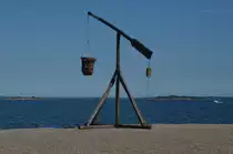 ,,Ein uralter Leuchtturm`` (Feuerkorb)  F�r den Ostseeraum typisch waren die Wippfeuer.  Der Eisenkorb mit dem Kohlefeuer wurde hier �ber einen langen Balken mit Gegengewicht in die H�he geschwenkt, damit die Schiffe den Hafen finden konnten. Gesehen in Karlskrona am 19.07.2014.