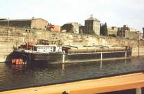 Das kleine DDR-Motorschiff  Warnem�nde  im Magdeburger Handelshafen. Im Vordergrund das Schanzkleid vom MS  Aken . Scan von einem Dia, ca. 1987/88. Weitere Infos zum Schiff gibt es da: http://www.ddr-binnenschifffahrt.de/index.htm