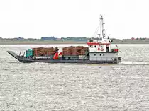 Das Mehrzweckschiff Janssand (Baujahr 1954) bringt einen mit Faschinen beladenen LKW zur ostfriesischen Insel Spiekeroog. Faschinen sind Reisigbündel, die zum Küstenschutz verwendet werden. (15. Mai 2014) 