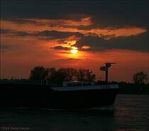 Jenseits von Afrika - Die  Febe  passiert im Sonnenuntergang den Rhein bei Duisburg-Schwelgern.