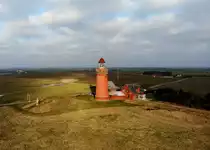 Bovbjerg Fyr. Der 26 m hohe Leuchtturm wurde 1877 auf dem höchsten Punkt der Steilküst von Bovbjerg errichtet. Dadurch beträgt seine Feuerhöe 62 m über dem Meer. Seine markant rote Farbe sollte ihn von den Kirchtürmen von Ferring und Trans unterscheiden. Drohnenaufnahme aus 39m Höhe vom 17.02.2019