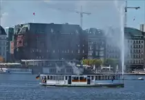 Das Alster Dampfschiff „St Georg“, hat soeben ihren Anleger am Jungfernstieg auf der verlassen und f�hrt an der Alsterfont�ne auf der Binnenalster vorbei. 18.09.2019