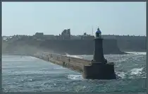 Die Nordseewellen schlagen am 17.05.2025 gegen den North Pier mit dem Leuchtturm Tynemouth. Oberhalb der Steilküste sind die Ruinen von Tynemouth Castle zu sehen.