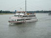 Ein Ausflugsschiff vor der Rheinpromanade in D�sseldorf mit der Oberkasseler Br�cke im Hintergrund am 26.06.2004.