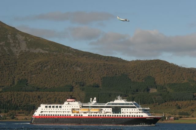 Whrend die M/S  Midnatsol  Stokmarknes sdgehend verlsst, setzt ein Linienflugzeug zur Landung an; 14.09.2006