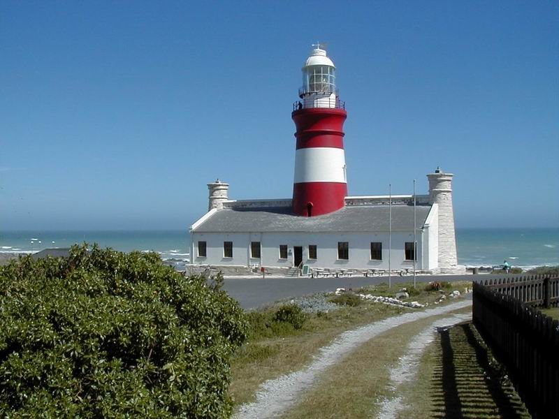 Wahrscheinlich eines der schnsten Leuchttrme der Welt. Am Sdlichsten Zipfel des Afrikanischen Kontinents, an der gefhrlichen Cape Agulhas Ksten Linie steht der im Stil des Pharaos von Alexandria kopierte Leuchtturm. Der Bau fing am 1 April 1847 an und endete Dezember 1848. Erst mit 4500 Kerzen Strke ausgerstet ging das Licht zum Indischen und Atlantischem Ozean hin. 1914 wurde ein Optisches drehendes Licht mit einer Strke von 470.000 Kerzen in Gebrauch genommen, welches alle 4 Sekunden aufleuchtete. 1936 endlich wurde ein Elektrisches Licht mit 12.000.000 Kerzen Strke in den Turm gesetzt. Leider wurde der Leuchtturm ber 26 Jahre nicht benutzt, bis endlich 1973 dieses schne, historische Gebude zum Denkmalschutz erklrt wurde. In der Zwischenzeit wurde der Turm renoviert, ein Museum wurde erffnet und seit Mrz 1988 strahlt wieder der Lichtstrahl ber beide Ozeane. Es ist auch hier und nicht am Cape Point bei Kapstadt, wo sich der Indische und Atlantische Ozean treffen. Dieses Bild macht ein guter Hintergrund auf dem Monitor. 