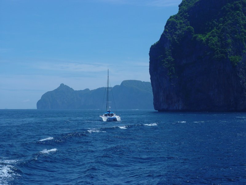 Zwischen den vielen Inseln in der Andaman See dmpelt dieser Katamaran vor sich hin. Gesehen am 23.04.2006 auf der Fahrt von Phuket town nach Krabi.